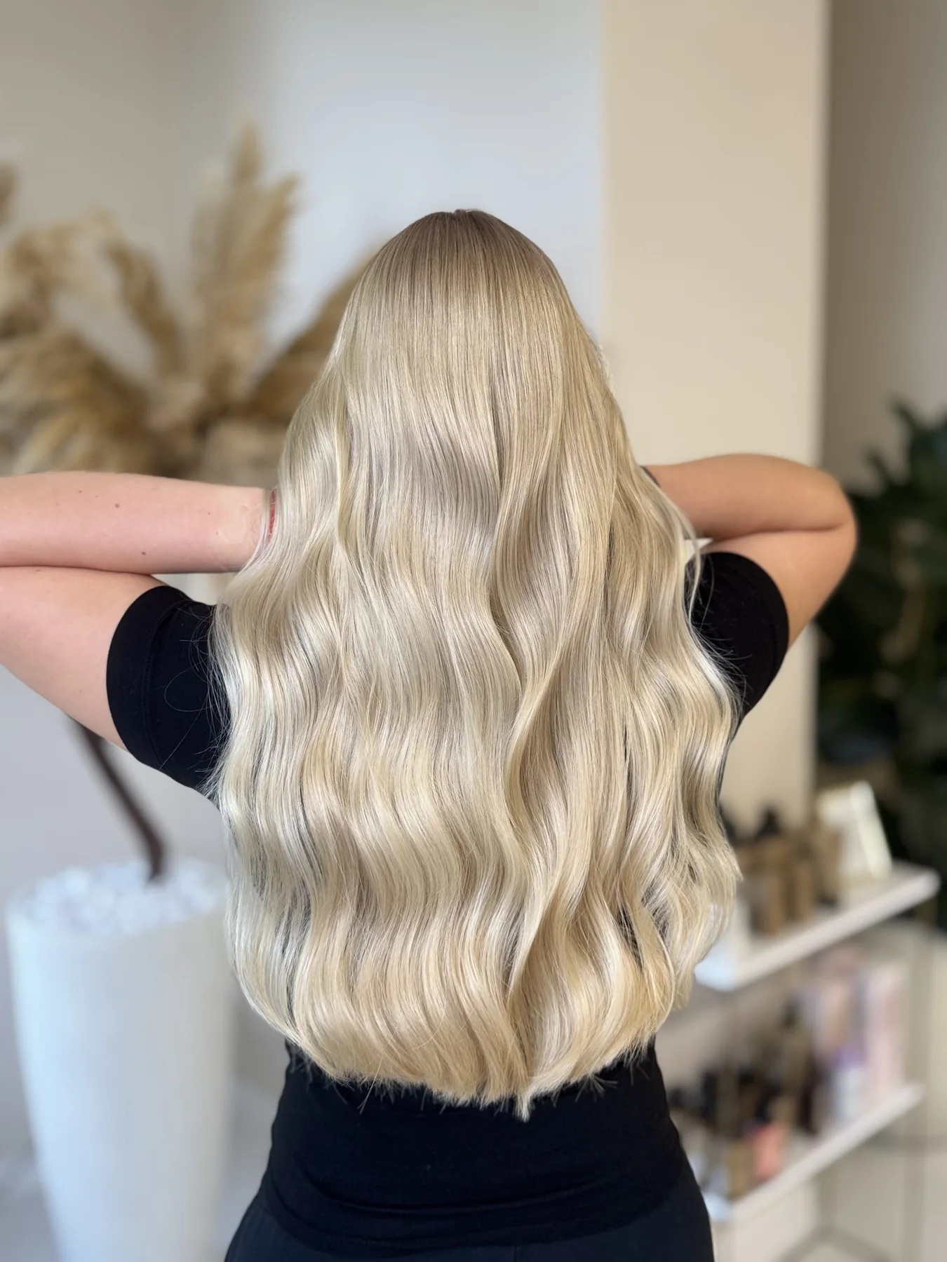 Długie blond włosy ułożone w miękkie fale, widok od tyłu.