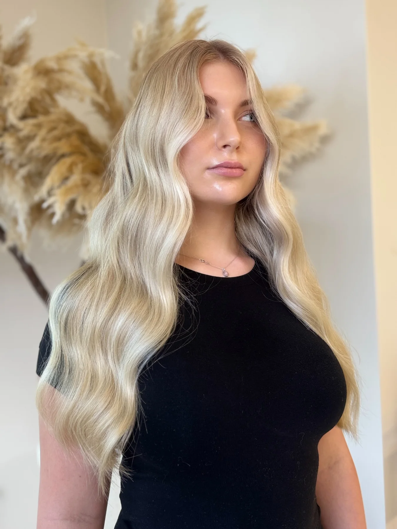 Portret klientki z długimi, sprężystymi blond lokami.